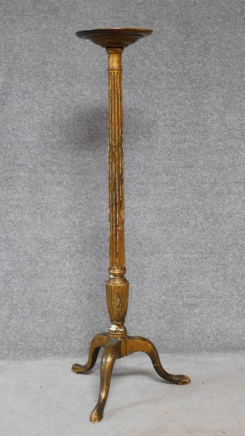 An antique giltwood torchere on turned fluted pedestal support terminating on tripod cabriole