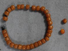 A string of thirty one very large copal resin beads and two smaller loose ones. Largest beads