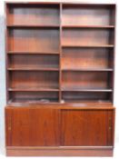 A mid 20th century rosewood open library bookcase with sliding doors to base cupboards, raised on