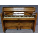 An Art Deco figured walnut upright piano, by Nathaniel Berry & Sons. H.106 W.133 D.48cm