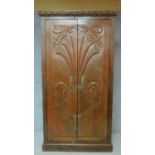 An Art Nouveau style chestnut wardrobe with shell carved panel doors enclosing shelved interior. H.