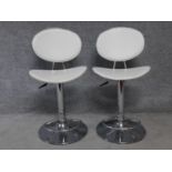 A pair of contemporary leather upholstered rise and fall swivel action bar stools on chrome pedestal