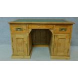 A 19th century pitch pine desk with leather top and two short drawers over panel doors enclosing