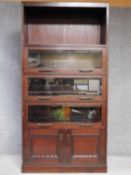 An early 20th century oak bookcase with open upper section above three bevelled glazed sections