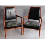 A pair of Danish 1970's vintage teak framed armchairs in deep green leather upholstery. H.97cm