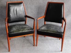 A pair of Danish 1970's vintage teak framed armchairs in deep green leather upholstery. H.97cm