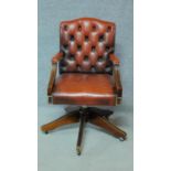 A Georgian style mahogany framed buttoned back leather upholstered office swivel desk armchair. H.