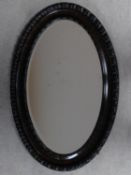 An early 20th century oval wall mirror with gadrooned frame and bevelled plate. 83x55cm