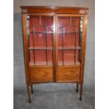 An Edwardian mahogany and inlaid display cabinet with astragal glazed doors on square tapering