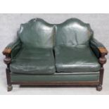 A mid 20th century carved oak frame leather upholstered two seater sofa on bulbous reeded