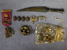 A collection of military regalia and brass buttons along with a bone handled dagger with hammered