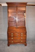 A Georgian mahogany bureau bookcase, the upper glazed section above fall front revealing well fitted