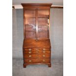 A Georgian mahogany bureau bookcase, the upper glazed section above fall front revealing well fitted