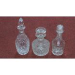 Two Victorian and one Georgian blown clear cut glass decanters with stoppers. H.29cm
