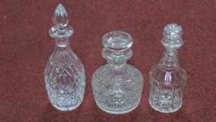 Two Victorian and one Georgian blown clear cut glass decanters with stoppers. H.29cm