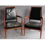 A pair of Danish 1970's vintage teak framed armchairs in deep green leather upholstery, retail label