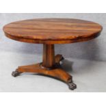 An early 19th century rosewood circular tilt top dining table on tripod pedestal base terminating on