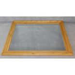 A large pitch pine framed bevelled wall mirror. H.151xW.122cm