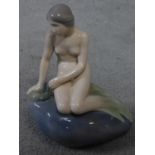 A Royal Copenhagen porcelain model of the harbour mermaid. Signed to the back. Marked to base