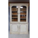 A 19th century painted bookcase/dresser with glazed doors enclosing shelves above panel doors. H.