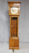 An oak cased grandfather clock, with gilded repousse detailing to the face. Black roman numerals