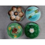 Four antique majolica plates. One designed by George Jones of pineapples in a basket, the waterlilly