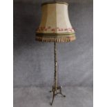 A vintage tripod base brass standard lamp with sectioned detailing. H.176cm