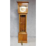 An oak cased grandfather clock, with gilded repousse detailing to the face. Black roman numerals