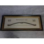 A framed shadow box Asian/mayan replica of a bow and arrow. The bow features authentic styled