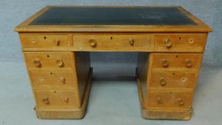 A 19th century oak leather top desk with central long frieze drawer and eight short drawers. H.75