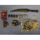 A collection of military regalia and brass buttons along with a bone handled dagger with hammered