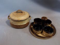 A studio pottery lidded pot and ramekin holder. The lidded two handled pot has an impressed cross