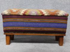 A kilim upholstered foot stool on square feet. H.42 L.75 W.27cm