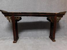 A Chinese hardwood altar table on carved trestle supports. H.93 W.179 D.31cm