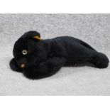 A Steiff vintage toy of a young black panther. With label and gold button. Plastic eyes. W.31cm