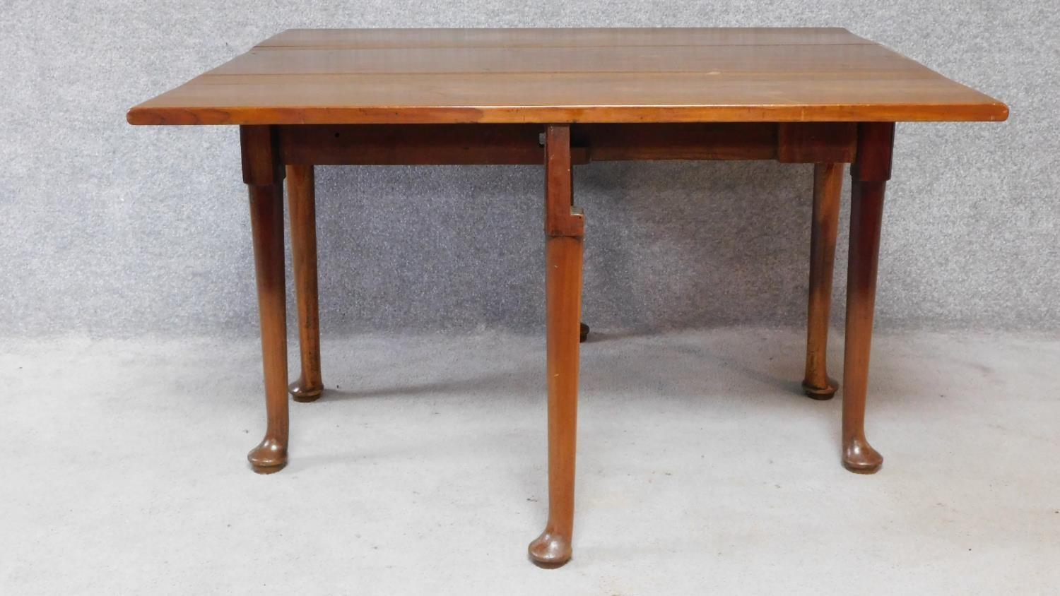 A Georgian Cuban mahogany drop flap gateleg dining table on six pad foot supports. H.70xW.119xD. - Image 3 of 4