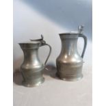 Two lidded pewter tankards, circa 1800. One with acorn detailing to handle and one with a scallop