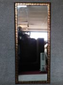 A studded and metal bound framed wall mirror. 164x73cm