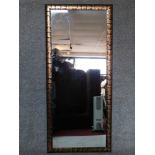 A studded and metal bound framed wall mirror. 164x73cm