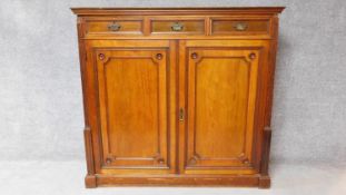 A 19th century mahogany press cupboard with three frieze drawers over panel doors enclosing linen
