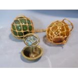 Two antique fishing floats and a brass ship's compass ashtray. H14cm.