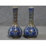 A pair of handpainted ceramic vases with a stylised floral and foliate design in blues, greens and