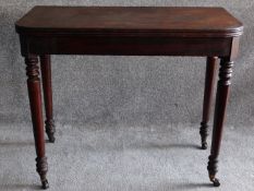 A 19th century mahogany foldover top tea table on turned tapering supports. H.74 W.45 D.92cm