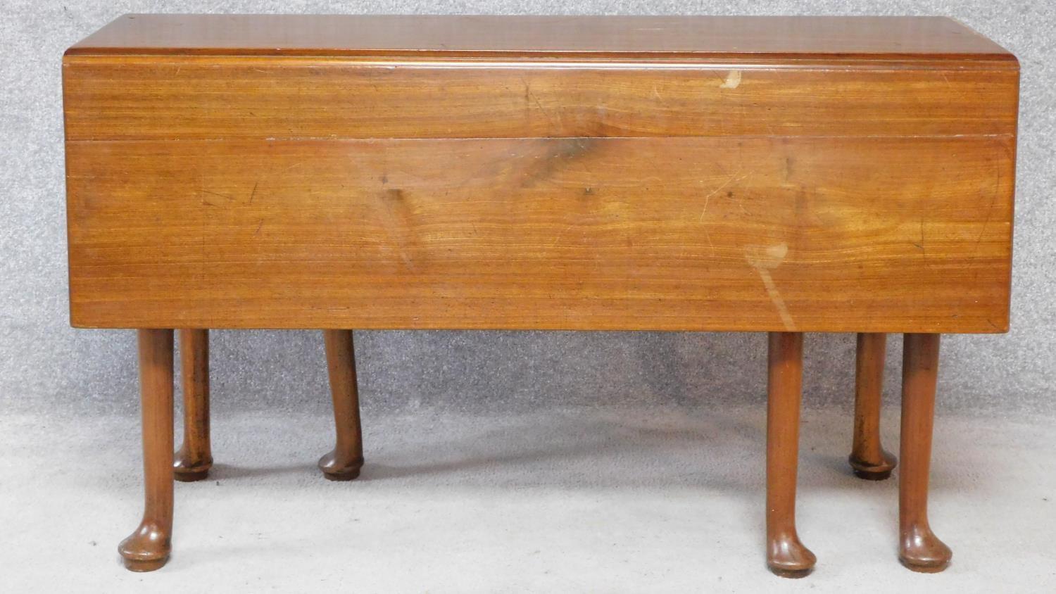 A Georgian Cuban mahogany drop flap gateleg dining table on six pad foot supports. H.70xW.119xD.