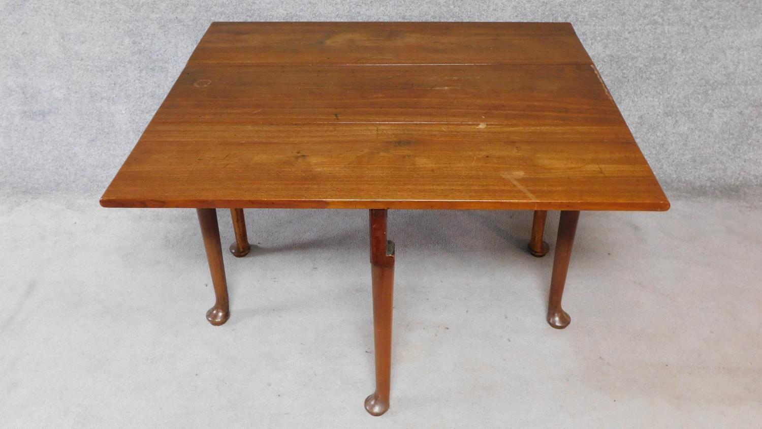 A Georgian Cuban mahogany drop flap gateleg dining table on six pad foot supports. H.70xW.119xD. - Image 2 of 4