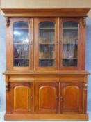 A Victorian style mahogany library bookcase with three arched glazed doors enclosing shelved