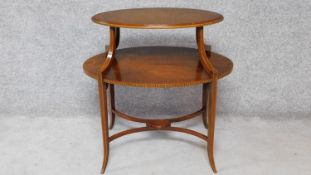 An Edwardian mahogany and satinwood inlaid two tier oval topped etagere on swept square
