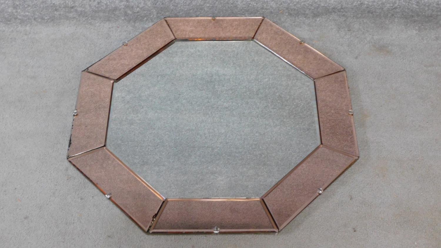 An Art Deco style mirrored peach glass octagonal bevelled wall mirror. H.80xW.80cm