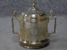 A white metal two handled antique biscuit tin, with gryphons to the handles and engraved foliate