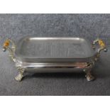 An antique turned ivory handled silver plated warming dish on four feet with repousse foliage and